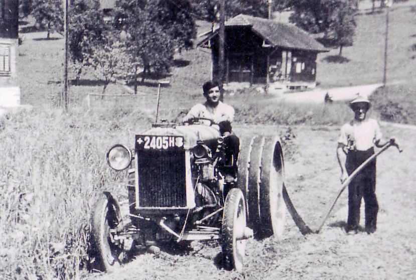 Emil Walker mit dem Traktor «Fordson» Jahrgang 1937, auf der 
Wiese vor dem Schulhaus